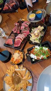 The video features a creator visiting Cow and Sow for their 'Steak Education' event, showcasing various cuts of steak, sides like mac and cheese and blooming onion, and wine pairings. It includes shots of the chef preparing the meat and the restaurant's exterior, providing a clear overview of the experience.