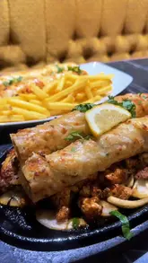 A creator visits Chowdreys in Bradford to showcase their new 'naanwich' and other menu items including curries, drinks, and desserts.