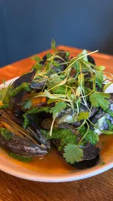 A review of Kelp in Glasgow, highlighting their sustainable Scottish seafood menu. The video features a variety of small plates, cocktails, and desserts, with a focus on the crab donut, scallops, and lamb shoulder.