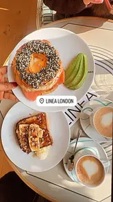 A short, aesthetic reel showcasing the interior and food offerings at Cafe Linea in Chelsea. The video features close-ups of a salmon bagel and French toast, followed by a tour of the cafe's stylish, light-filled interior.