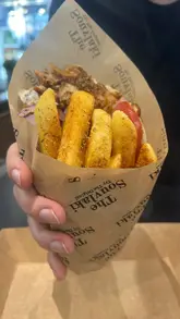 A montage of food shots at The Souvlaki in Kingston, featuring various Greek dishes like souvlaki, gyros, fries, and dips. The video focuses primarily on the food presentation on the table with brief shots of the restaurant exterior.