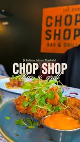 A group of friends visits Chop Shop Bar & Grill in Sheffield, capturing a variety of dishes including halloumi fries, pork tacos, fried chicken, and a large butcher's block platter. The video features close-up shots of the food, the restaurant interior, and the group enjoying their meal, set to upbeat music.