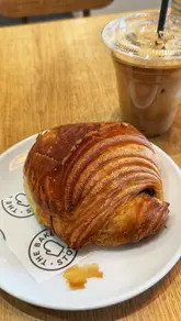 A short, relaxed video showcasing a visit to a bakery, featuring a pan of the pastry display and the creator enjoying a coffee and pastry.