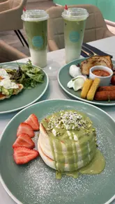 A short promotional video for Sipping Boba, showcasing their brunch menu including soufflé pancakes, croffles, and matcha drinks. The video features the creator presenting the food in a bright, modern cafe setting.