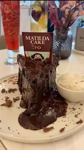 A review of Haute Dolci in Cabot Circus, focusing on their signature Matilda Cake, a Ferrero Rocher sundae, and mocktails. The video highlights the indulgent nature of the desserts and the cafe's aesthetic.