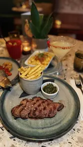A montage-style video showcasing the interior, food, and cocktails at Pique Gosforth. The video features close-up shots of various dishes like tuna tataki, picanha steak, and skewers, alongside atmospheric shots of the restaurant's decor.