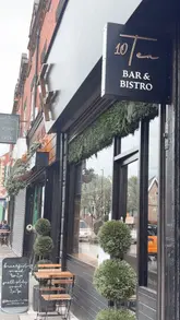 A short, fast-paced montage showcasing the interior and Sunday roast offerings of 10/TEN. The video features shots of the restaurant's decor, including a neon sign and swing, followed by close-ups of a Sunday roast, pork crackling, and dessert.