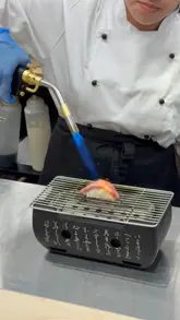 A promotional reel for a sushi hand roll bar in London, highlighting the freshness of the ingredients and the specific '15-second' consumption rule for their hand rolls. The video features close-ups of food preparation, including blowtorching and assembly, alongside shots of the venue interior and the creator sampling the dishes.