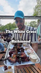 A creator reviews The White Cross pub in Richmond, highlighting their new chicken menu, including glazed wings, burgers, and spice bags. The video features the riverside outdoor seating area, cocktails, and the general pub atmosphere, including sports screens.