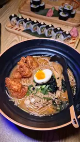 A promotional video featuring a visit to Maki & Ramen, showcasing the restaurant's interior, including cherry blossom decor, and a variety of dishes and cocktails.