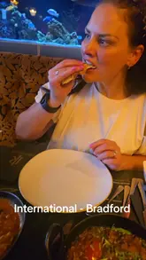 A family vlog-style review of a curry restaurant in Bradford, showcasing the entrance, table setting, and various dishes including poppadoms, samosa chaat, lamb chops, and curries.