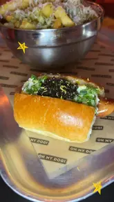 A creator visits Seven Dials Market to review the viral 'Caviar Cream Cheese Dog' from Oh My Dog. The video features a taste test of the hot dog, honey truffle fries, and a caviar sundae, providing a personal and enthusiastic review of the unique menu items.