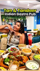 A short, energetic video showcasing a visit to Tap & Tandoor, an Indian gastro pub. The creator highlights the food, cocktails, and entertainment options like darts and shuffleboard, while providing a quick tour of the venue's interior.