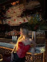 A high-quality, atmospheric portrait of a woman posing at a bar in Ce La Vie London, effectively showcasing the venue's upscale, moody interior design and sophisticated lighting.