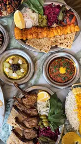 A montage of a restaurant visit featuring table settings, a variety of Middle Eastern-style dishes including kebabs, dips, rice, and desserts, accompanied by tea and drinks.
