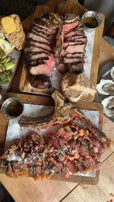 A fast-paced, engaging review of The Rock Inn in Chiddingstone, Kent. The video highlights their Basque-style cooking, specifically focusing on 45-day dry-aged steaks, alongside other menu items like battered oysters, a pint of prawns, homemade pies, and desserts like trifle and Basque cheesecake.