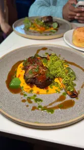 A high-quality, slow-motion montage of a five-course tasting menu, featuring close-ups of focaccia, croquettes, a poached egg dish, lamb breast, and a lemon parfait dessert.