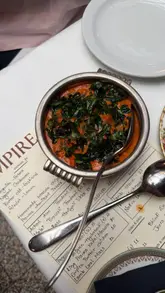 A review of Empire Empire, an Indian restaurant in London, showcasing dishes like lamb chops, lobster biryani, and a meringue cheesecake.
