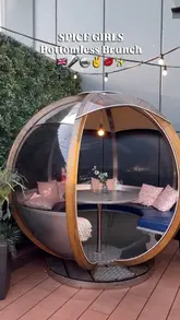 A short, high-energy video showcasing a Spice Girls-themed bottomless brunch. The creators dance and pose in a venue decorated with pink furniture, neon lights, and disco balls, while holding cocktails. The video focuses on the fun, social atmosphere of the event.