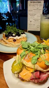 A promotional video for The Pen and Pencil in Manchester, showcasing their new menu items including blueberry pancakes and a burger, alongside their brunch and lunch offers.