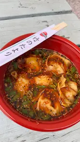 A creator visits Phat Boi at Dunkertons Park to try their new menu items, including pork wontons, a Kung Phu burger, and sesame tan tan ramen. The video features close-up shots of the food and the creator's reactions, set within the casual outdoor environment of the venue.