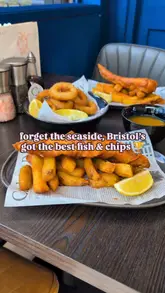 A short, energetic review of a fish and chip shop in Bristol, highlighting their £10 lunch deal. The video features close-up shots of the food, including fish and chips, calamari, and curry sauce, with a voiceover describing the quality and value.