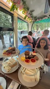 A video showcasing an afternoon tea experience on a double-decker sightseeing bus in London, featuring views of landmarks like Big Ben and the London Eye while enjoying sandwiches, scones, and pastries.