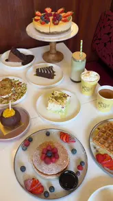 A fast-paced, high-energy montage showcasing a wide variety of desserts, street food, and drinks at a modern cafe. The video focuses on close-up shots of food preparation and presentation, highlighting the venue's aesthetic and menu diversity.
