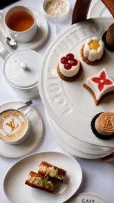A high-end, aesthetic montage showcasing an afternoon tea experience at the Louis Vuitton-themed Café Alma pop-up in London, highlighting the branded patisseries, elegant table setting, and sophisticated atmosphere.