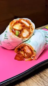 A food review video featuring a visit to Chit 'n' Chaat at the Trafford Centre to try their new menu additions, including various chicken wings, wraps, dahi puris, lamb chops, and chocolate samosas.