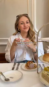 A montage video showcasing an afternoon tea experience at Bettys in Harrogate. The video features close-ups of the tiered food stand, tea pouring, the interior of the tea room, a live piano player, and the creator enjoying the experience.