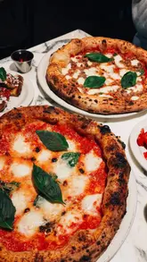 A short, punchy reel showcasing a visit to Paesano Pizza in Edinburgh. The video features close-up shots of various menu items, including pizzas, bruschetta, burrata, and a cheesecake dessert, set to music with text overlays.