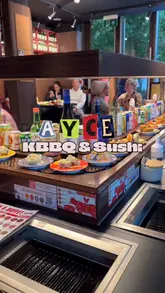 A short, punchy reel showcasing an All-You-Can-Eat Korean BBQ and sushi restaurant. The video highlights the unique dining format, featuring a conveyor belt for sushi and drinks alongside personal tabletop grills for cooking meat.