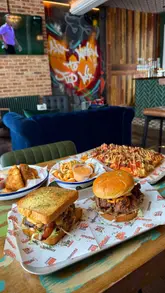 A creator visits Fupburger at its new location within Three Stories in Norwich. The video features a mix of venue tour footage, close-ups of various menu items including burgers, Detroit-style pizza, and sides, and the creator sharing their experience.