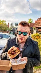 Here are a few options for your SEO alt text, keeping it under 125 characters:

**Option 1 (Focus on location and food):**
Juicy burger served from the Burger at Friends food truck parked outside The Greyhound pub in Whitchurch on Thames.

**Option 2 (Action-oriented):**
A delicious gourmet burger from the Burger at Friends van parked at The Greyhound in Whitchurch on Thames.

**Option 3 (Concise):**
Gourmet burger held by a hand in front of the Burger at Friends food van at The Greyhound pub in Whitchurch.