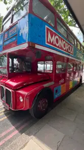 A short video showcasing a Monopoly-themed afternoon tea experience on a London Routemaster bus. The video features shots of the bus interior, the table setting with various afternoon tea treats, the interactive Monopoly board on a tablet, and the staff serving scones.