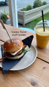 A montage video showcasing Bowden Stores, a cafe and homeware shop. The video features shots of the exterior, the interior dining area, close-ups of a burger and smoothie, and a tour of the retail shelves displaying various products.