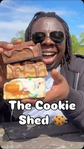 A creator visits a unique 'Cookie Shed' that operates on an honesty box system, showcasing a variety of loaded cookies and bakes while explaining the self-service concept.