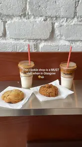 A short, punchy video showcasing a cookie shop in Glasgow. It features shots of the shop's interior, the display case filled with various cookies, and close-ups of the product, including a satisfying shot of a cookie being broken open.