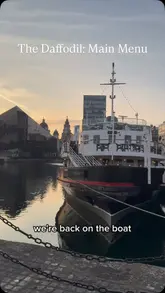 A couple reviews a floating restaurant, showcasing the interior, atmosphere, and a variety of dishes including starters, mains, and desserts. The video features energetic commentary and close-up shots of the food.