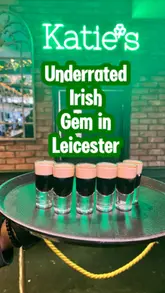 A promotional montage for Katie O'Brien's Irish Tavern, featuring close-ups of Baby Guinness shots being poured, a variety of drinks on a table, and shots of the pub's interior and exterior.