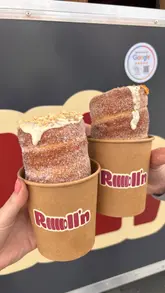 This reel features a food truck specializing in chimney cakes, documenting the preparation process from dough rolling to the final decorated product. It includes shots of the menu, the cooking process, and the finished desserts paired with iced coffee drinks.