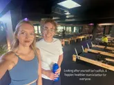 A selfie of two women in a pilates studio, likely used to promote a fitness venue or community-focused fitness class. The image captures a candid moment between friends, emphasizing the social and mental health benefits of exercise and community.