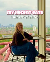 A high-quality, well-composed portrait of a creator sitting in front of a large window with a city skyline view, serving as a cover image for a home cooking content series.