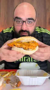 A food review vlog featuring a visit to Ario's in Bolton. The creator samples the spicy dipped wings, a 'daddy burger,' peri chicken with rice, and a milk cake dessert, providing commentary on the flavor and quality of the food.
