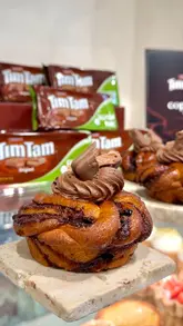 A short, engaging video showcasing a limited-edition gluten-free babka collaboration between Copains bakery and Tim Tam. The creator visits the shop, shows the product, and gives a brief review, highlighting the atmosphere and the specific ingredients.