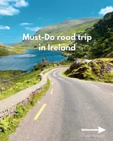 A visually appealing travel-focused social media post promoting a scenic road trip route in Ireland. The image features a high-quality landscape shot of a winding road set against a backdrop of mountains and a lake, effectively using leading lines to draw the viewer into the scene.