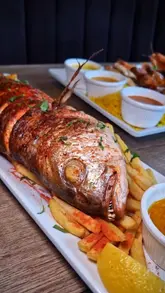 A promotional reel featuring a creator visiting Shrimp & Co to showcase their new menu items, including a large snapper, seafood platters, mocktails, and a chocolate lava cake.