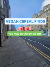 A generic, eye-level street photograph used as a background for a text-heavy social media post about vegan cereal options at a supermarket.