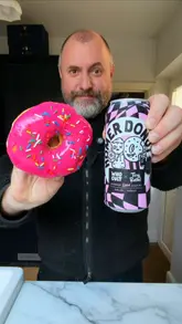 The creator unboxes a collaboration package between Tiny Rebel and Who Cult Donuts, featuring a raspberry donut IPA. The video includes a demonstration of the product and a humorous, albeit gimmicky, attempt to 'filter' the beer through a donut.